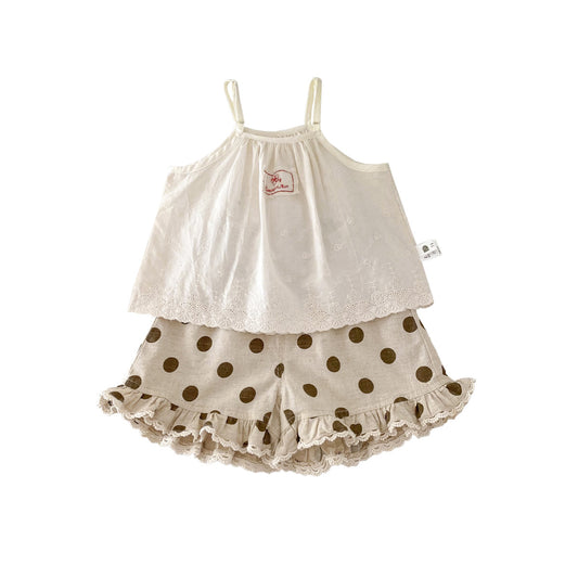 A set of an apricot-colored doll-style blouse and polka-dot shorts for little girls