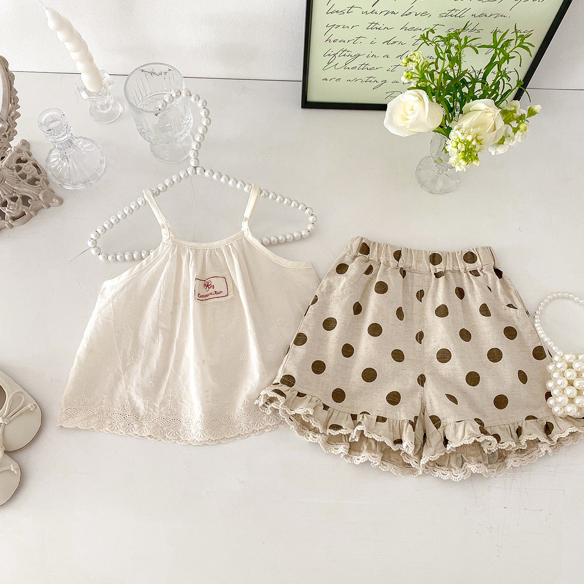 A set of an apricot-colored doll-style blouse and polka-dot shorts for little girls
