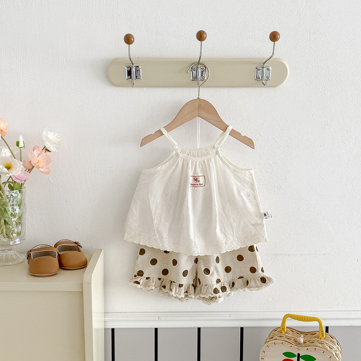 A set of an apricot-colored doll-style blouse and polka-dot shorts for little girls