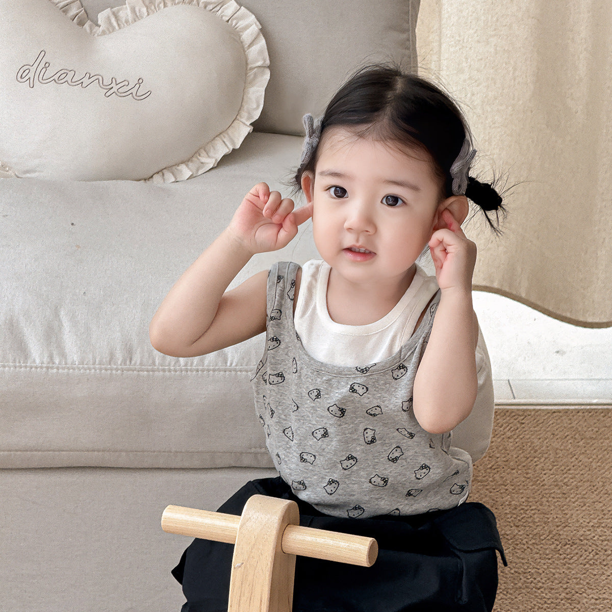 A set of a gray Kitty-themed vest and a black utility-style short skirt for little girls