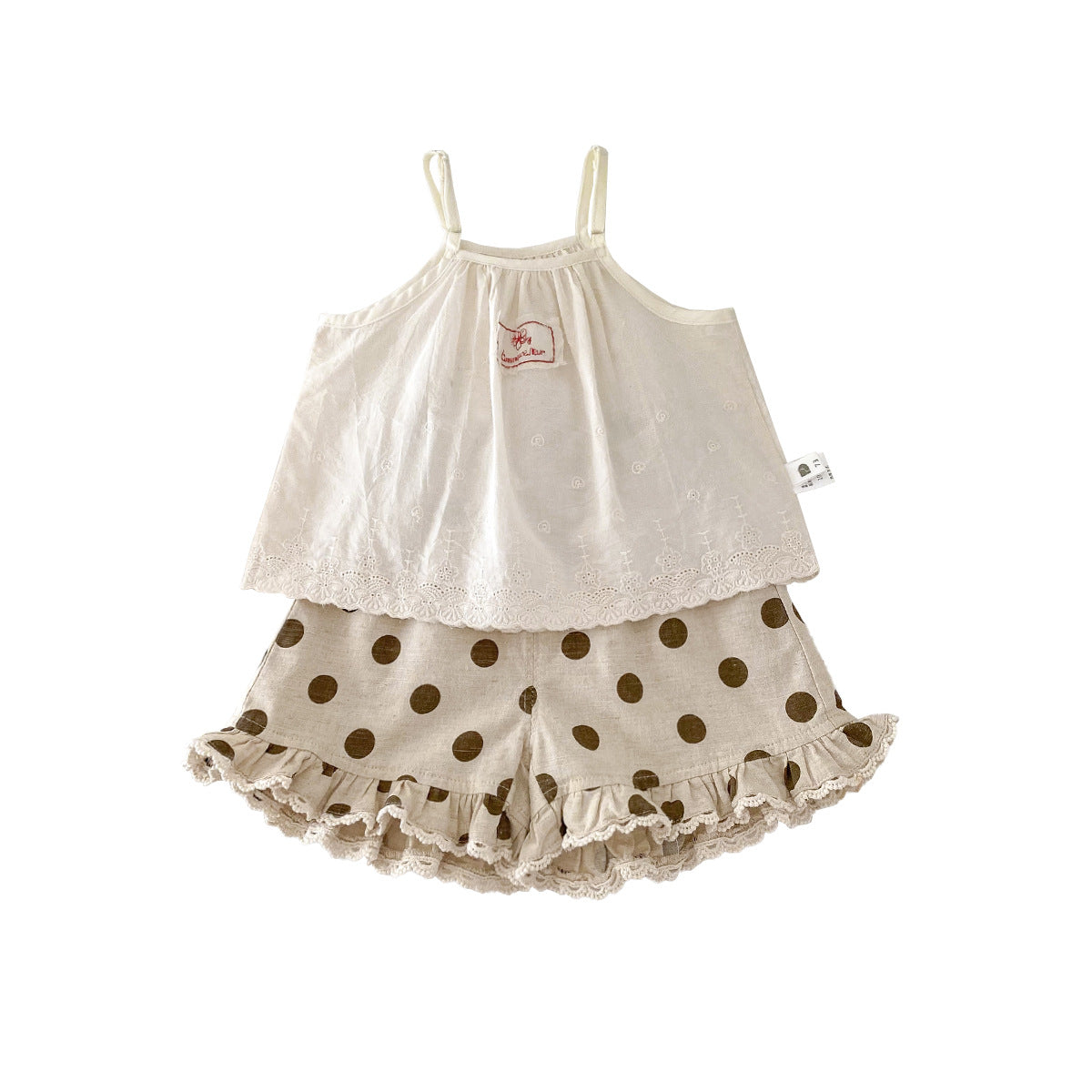 A set of an apricot-colored doll-style blouse and polka-dot shorts for little girls